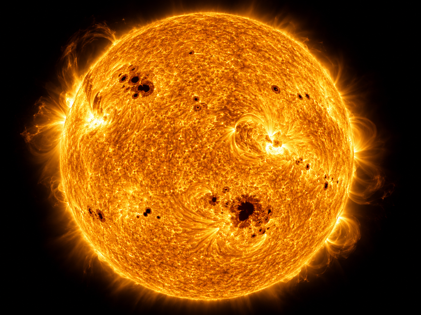 The Sun’s turbulent surface shows sunspots at different latitudes as evidence of its uneven rotation.